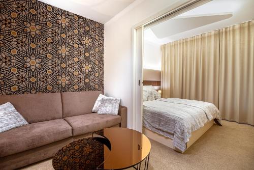 a living room with a couch and a bed at Apartmán LIANA Hrebienok C206 in Smokovce