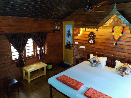 a room with two beds and a table in it at Sea Hut Homestay in Cochin