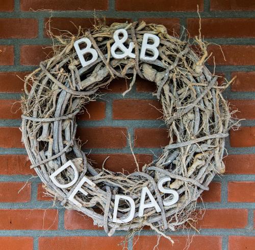 a wreath on a brick wall with the wordsario at B&B de Das in Stein