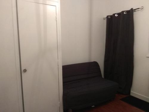 une chaise noire dans une chambre avec placard dans l'établissement Studio Moulins, à Moulins