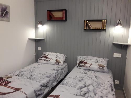 1 dormitorio con 2 camas y espejo en la pared en Appartement 4/6 pers plein sud. Front de neige en Isola 2000