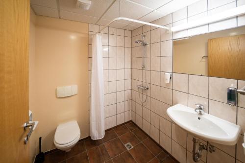 a bathroom with a sink and a toilet and a mirror at North Star Hotel Olafsvik in Ólafsvík