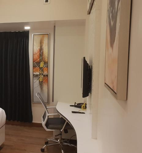 a office with a desk and a chair in a room at Hotel surya dev residency in Bengaluru
