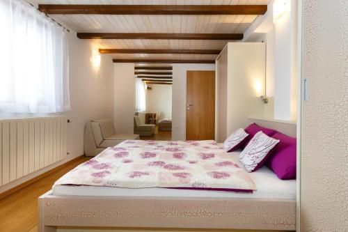 um quarto com uma cama grande e almofadas roxas em Villa Dora em Bajčići