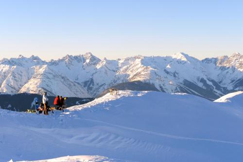 a group of people standing on top of a snow covered mountain at Appartement Mühle - including Summercard, Sauna, Kaprun's largest private garden with panoramic view in Kaprun