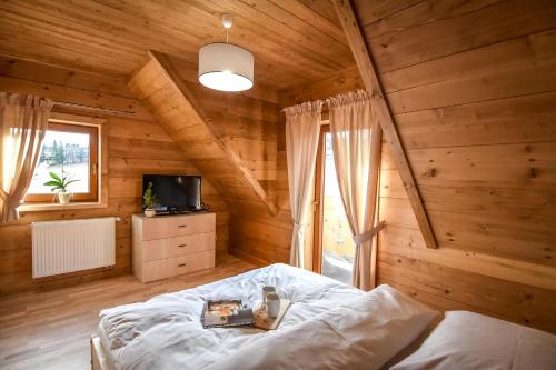 a bedroom with a bed in a wooden room at Domek Górski Zakątek in Nowe Bystre