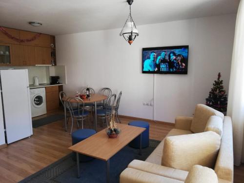 uma sala de estar com uma mesa e uma cozinha em Apartment Svetla in Laplandia Complex em Pamporovo