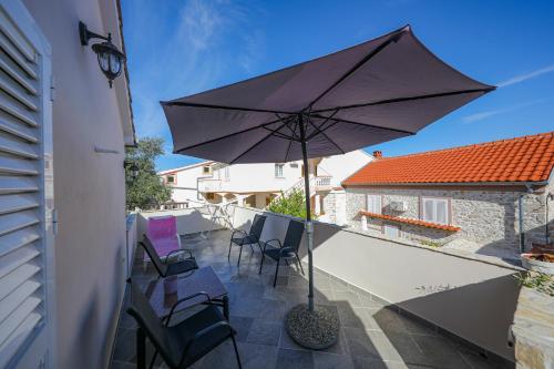 a patio with an umbrella and chairs on a balcony at Holiday Home Ana in Poljana