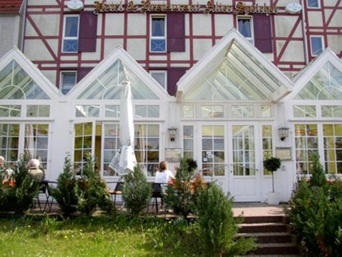 a building with a conservatory with people sitting in front of it at Hotel & Restaurant Alter Speicher in Greifswald