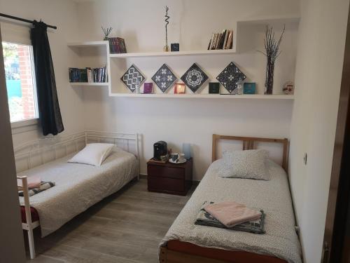 a bedroom with two beds and a window and shelves at Madrid Green in Villaviciosa de Odón