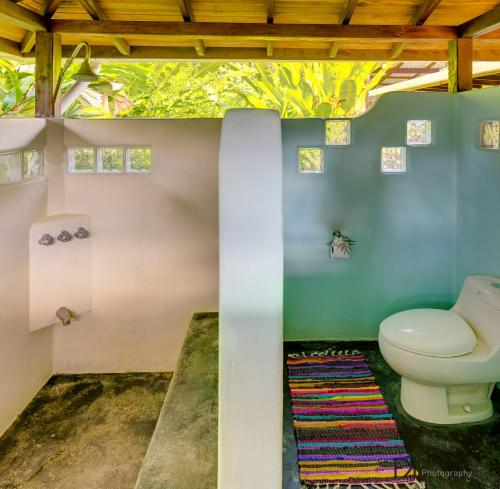 een badkamer met toilet in een kamer bij Casa Mil Flores in Cabo Matapalo