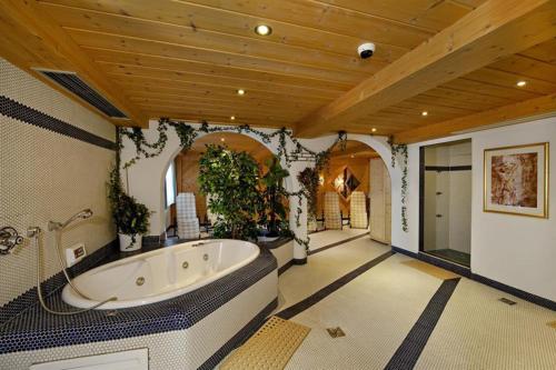 a large bathroom with a large tub with plants at Hotel Lasalt in Ischgl