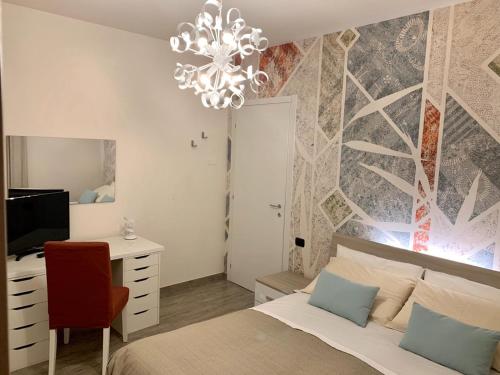 a bedroom with a bed and a desk and a chandelier at B&B Nearby Malpensa in Samarate