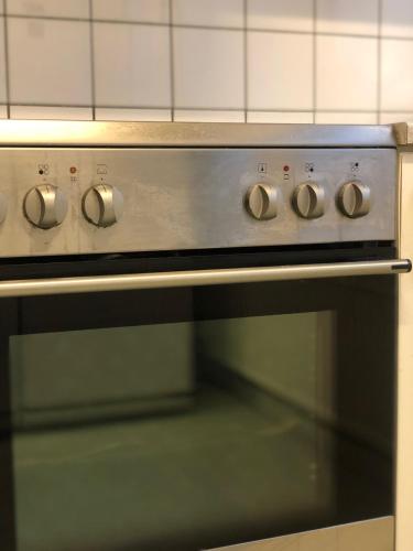 an oven with four knobs on the front of it at Harbour Living by Jutlandia - Hostel Style in Frederikshavn