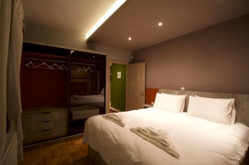 a bedroom with a large white bed and a mirror at Eros - Luxurious Apartment in Thessaloniki