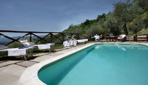 a swimming pool with chairs and a table and a table at VILLA BELLI - Luxury Villa with saltwater SWIMMINGPOOL in Agnino