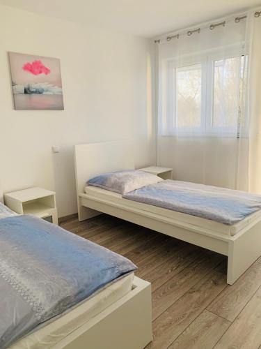 a bedroom with two beds and a window at IG-Apartments in Hattersheim