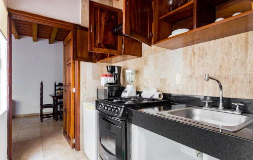 a kitchen with a sink and a stove at Olas Altas Suites Departamentos in Puerto Vallarta