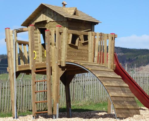 a wooden playset with a slide and a slope at Dümpelhof Ferienwohnungen in Olsberg