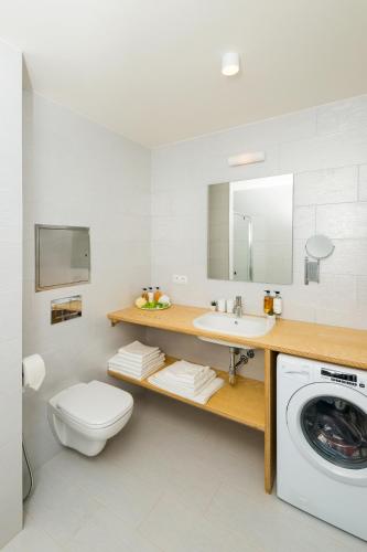 a bathroom with a washing machine and a sink at Residence Trafick in Prague