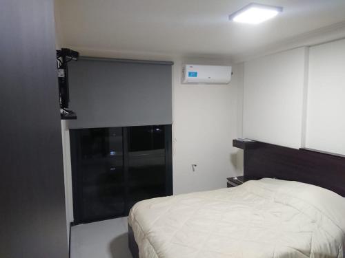 een kleine slaapkamer met een bed en een raam bij Serendipia Carlos Paz in Villa Carlos Paz