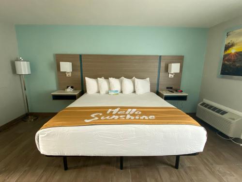 a hotel room with a large bed with a sign on it at Days Inn by Wyndham Rockport Texas in Rockport