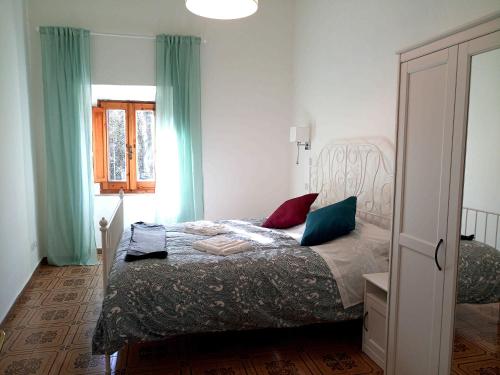 a bedroom with a bed with blue curtains and a window at Alloggio turistico Porta Franceta in Sutri
