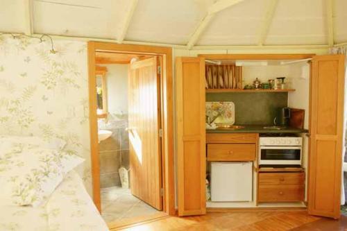 a room with a kitchen with a stove top oven at The Summerhouse, Ideal Akaroa location. in Akaroa