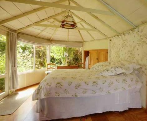 - une chambre avec un grand lit et une grande fenêtre dans l'établissement The Summerhouse, Ideal Akaroa location., à Akaroa