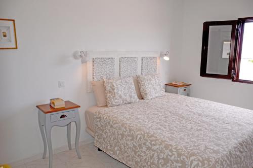 a white bedroom with a bed and a mirror at Villa Tranquilidad with amazing private terrace and heated pool in Charco del Palo