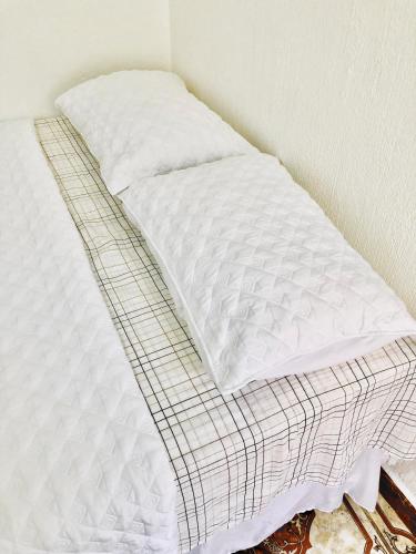 an unmade bed with white sheets on it at Casa Mama Fanti in Esquipulas