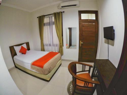 a bedroom with a bed and a desk and a chair at Griya Alsis Residence in Yogyakarta