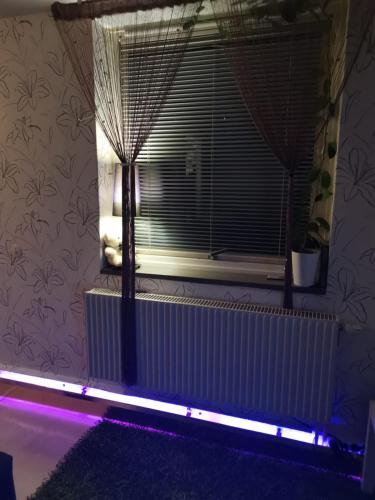 哥特堡的住宿－megness，配有散热器和紫色灯窗的房间