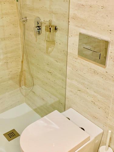 a bathroom with a white toilet and a shower at The Arch - Charming Apartments in the Historic Center in Braga