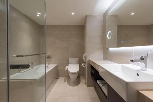 a bathroom with a tub and a toilet and a sink at K Hotel Taipei Chang-An in Taipei