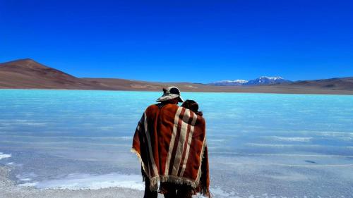 a man standing on the shore of a body of water at Hostal Sisabel in Tinogasta