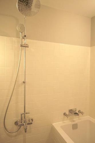 a bathroom with a shower and a tub and a sink at Just Sleep - Sanchong in Taipei