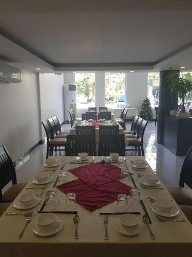 a table with a red umbrella on top of it at Apple Hotel Three - Phnom Penh in Phnom Penh