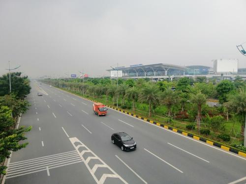 a highway with a car and a red truck at Sao Mai Cosy Nest-Noi Bai Airport in Thach Loi