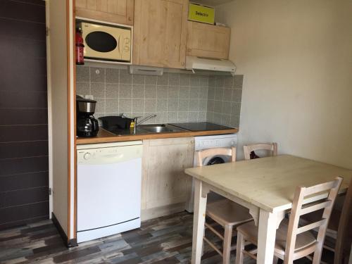 une petite cuisine avec une table et un évier dans l'établissement Loc luz st sauveur 4, à Luz-Saint-Sauveur