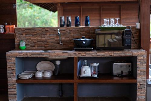 a kitchen with a counter with a microwave and a sink at Breeze Villa in Nusa Lembongan