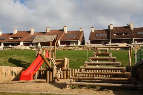 a playground in front of a building with a house at COMPEJO RAEIROS O GROVE, S Vicente do Mar in O Grove