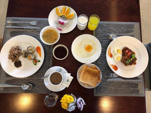 a table with plates of breakfast food and a cup of coffee at Ritzy Boutique Hotel Da Nang Beach in Da Nang