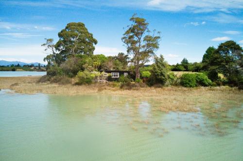 a house on an island in the middle of a lake at The Apple Pickers' Cottages in Mapua