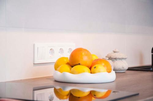 a bowl of fruit on a counter in a kitchen at Charme apartment in Jelgava