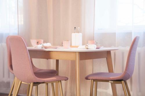 une table avec deux chaises et une table avec une bougie dans l'établissement Charme apartment, à Jelgava