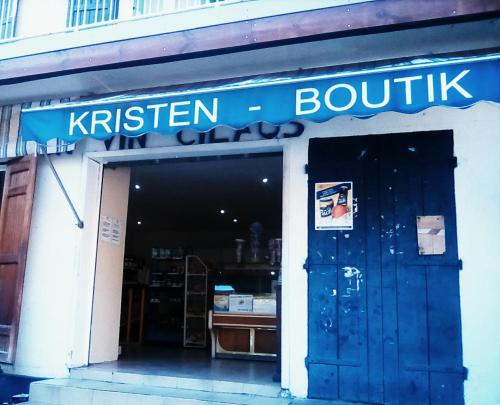 a store with a blue sign above a door at Auberge du Cap in Cilaos