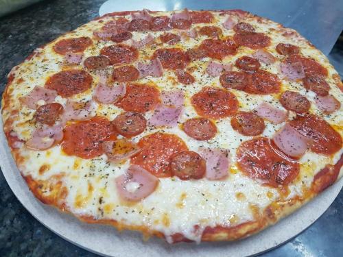 a pepperoni pizza sitting on top of a table at Hotel Mare Mare Inn in San Andrés