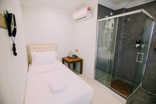 クアラルンプールにあるHotel Veniceのベッドルーム1室(シャワー、ガラスドア付きのベッド1台付)