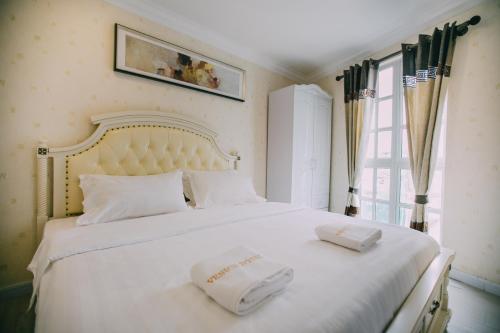 a bedroom with a white bed with two towels on it at Hotel Venice in Kuala Lumpur